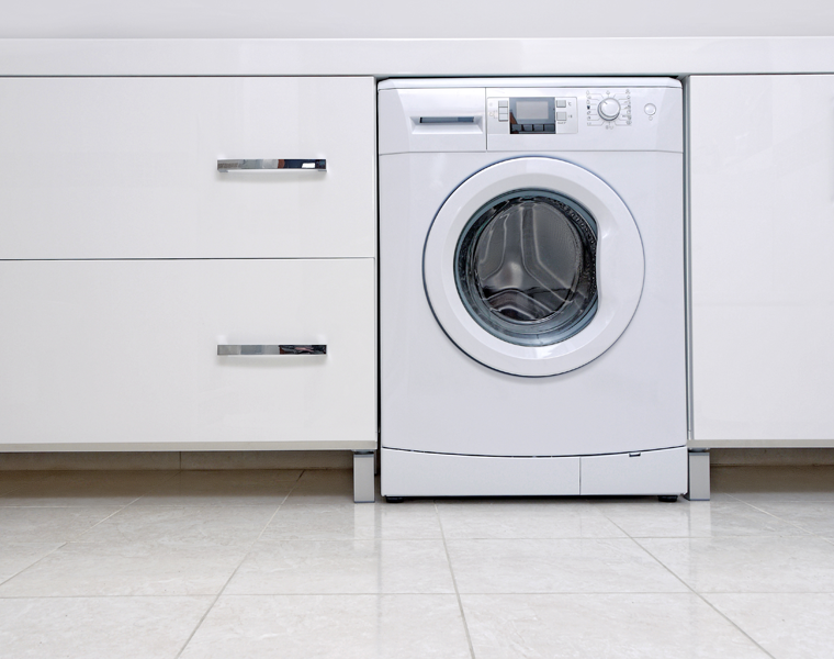 white washing machine in a white fitted kitchen 