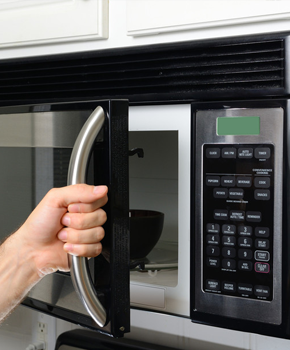 hand opening a microwave door